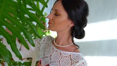 Genç esmer kadın gündüz tropikal parkta tek başına yürüyor.