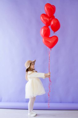 güzel kız kırmızı kalp balonları ile oturur