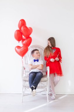 kız ve oğlan kırmızı kalp balonlar ile oturur