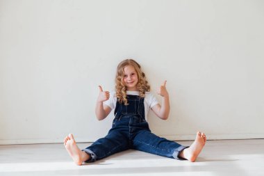 Sarışın kız odada başparmak gösterir