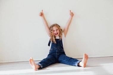 Sarışın kız odada başparmak gösterir