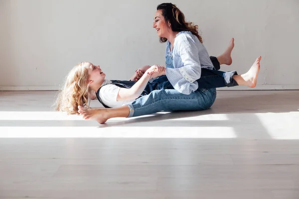 Mãe e filha brincam de abraços em casa no chão — Fotografia de Stock