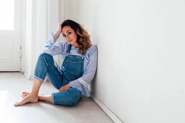 Retrato de uma mulher bonita em um macacão jeans — Fotografia de Stock