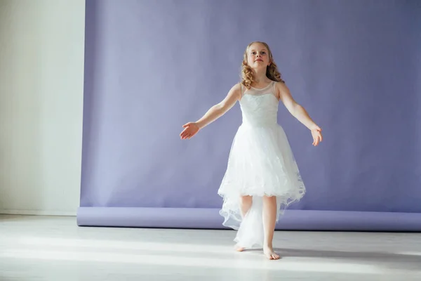 Menina de vestido branco dança sozinha no estúdio — Fotografia de Stock