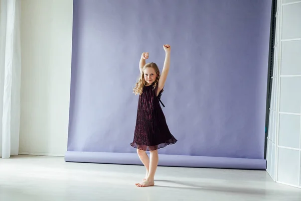 Girl in black dress dances alone to music