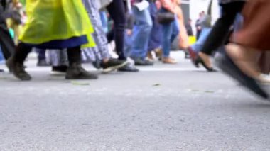 Yürüyen ve dışarıda sırada duran insanların bacaklar.