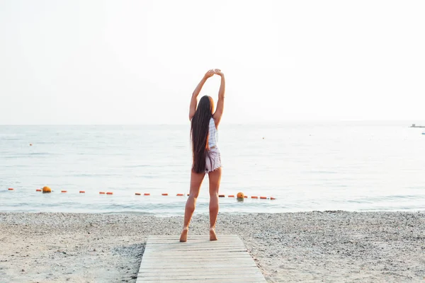 긴 머리를 가진 아름다운 여인 이 해변을 걷고 있다 — 스톡 사진