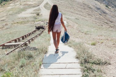 Uzun saçlı güzel kadın merdivenlerden iniyor.