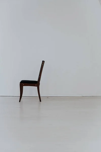 black chair stands alone in the white room