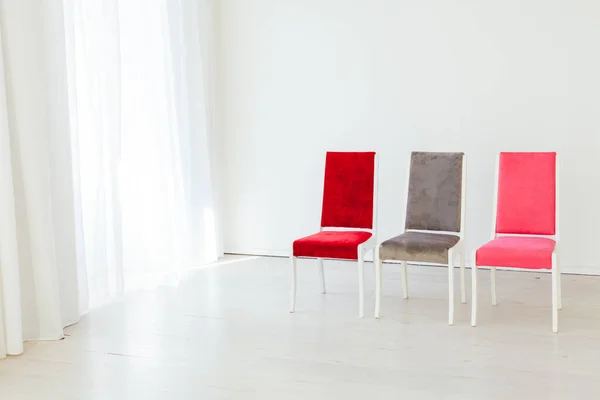 Três cadeiras estão em uma sala branca vazia — Fotografia de Stock