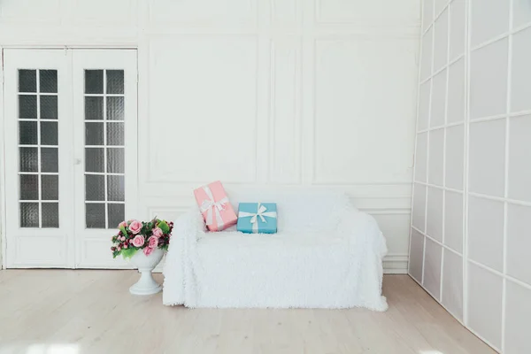 Sofa in the interior of the white room with blue and pink gifts for the surprise — Stock Photo, Image