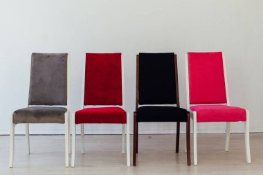 Boş beyaz bir odada dört sandalye duruyor.