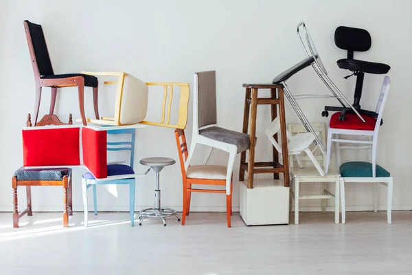 Molte sedie diverse stanno nella stanza bianca — Foto Stock