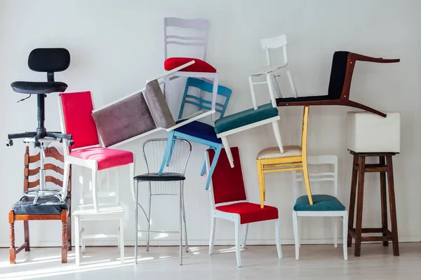 Many different chairs stand in the white room — Stock Photo, Image