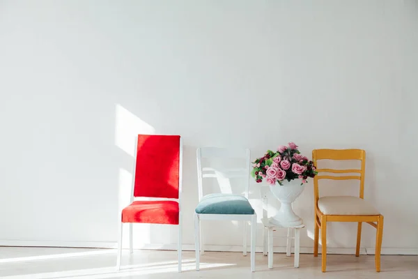 Quatro cadeiras e flores multicoloridas em um fundo branco — Fotografia de Stock