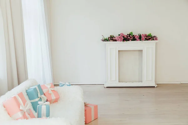 Sofá blanco y mesa con regalos y flores en el interior — Foto de Stock