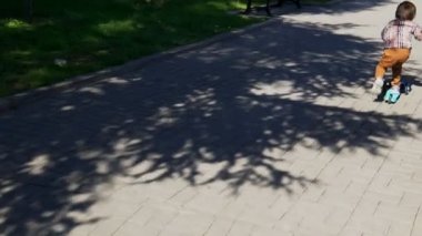 Çocuk parkta scooter kullanıyor. Kaygısız çocukluk