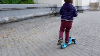 Çocuk parkta scooter kullanıyor. Kaygısız çocukluk