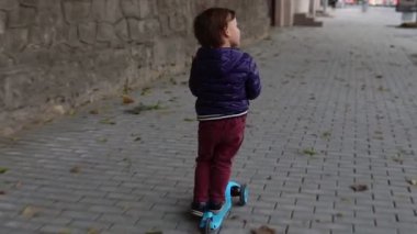 Sokakta scooter kullanan küçük çocuk