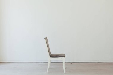 Boş beyaz bir odanın içinde bir gri sandalye.