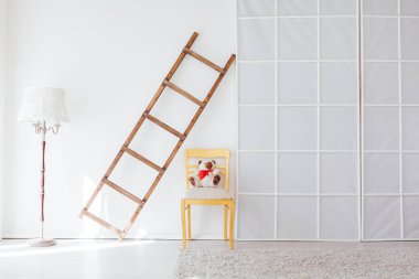 Beyaz odanın içindeki ahşap merdiven.