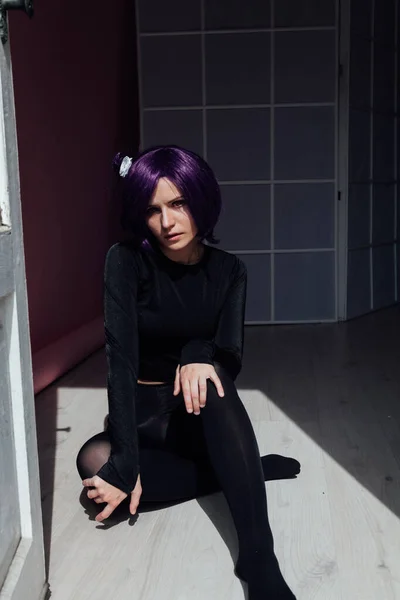 검은 옷을 입고 바닥에 앉아 있는 자주색 머리 소녀 — 스톡 사진