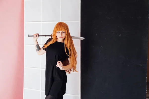 Woman cosplayer with red hair holds Japanese sword — Stockfoto