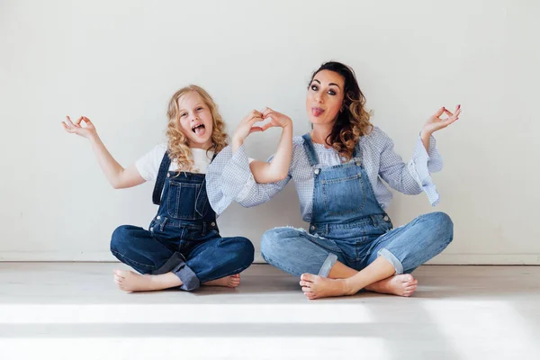 Máma a dcera v džínách mazlit smích — Stock fotografie