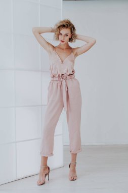 Beyaz arka planda pembe elbiseli güzel bir kadının moda portresi.