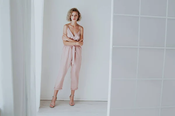 Retrato de moda de una hermosa mujer vestida de rosa en una habitación blanca —  Fotos de Stock