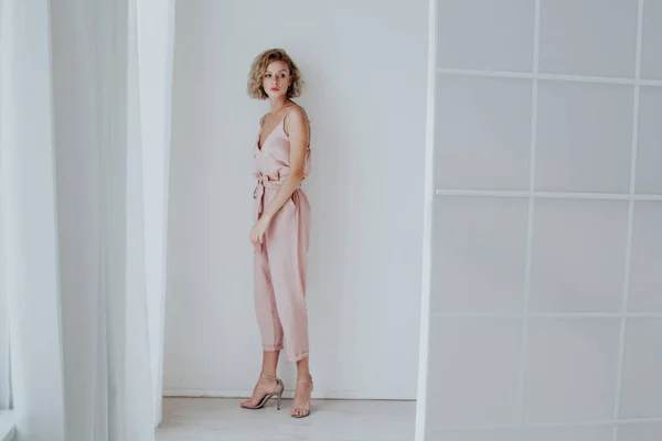 Ritratto di moda di una bella donna in abiti rosa in una stanza bianca — Foto Stock