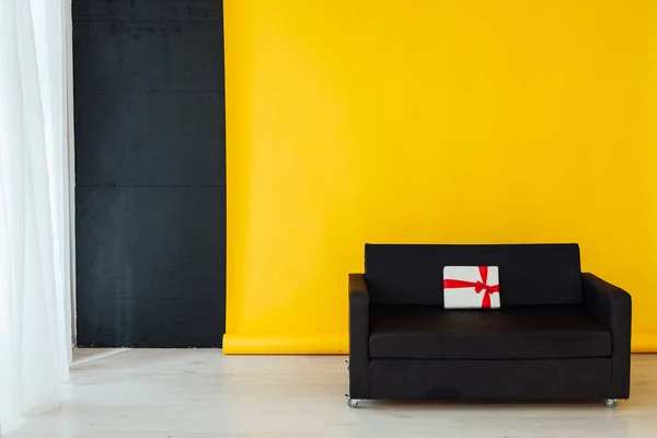 office sofa with red gifts in the interior of the room with a yellow background