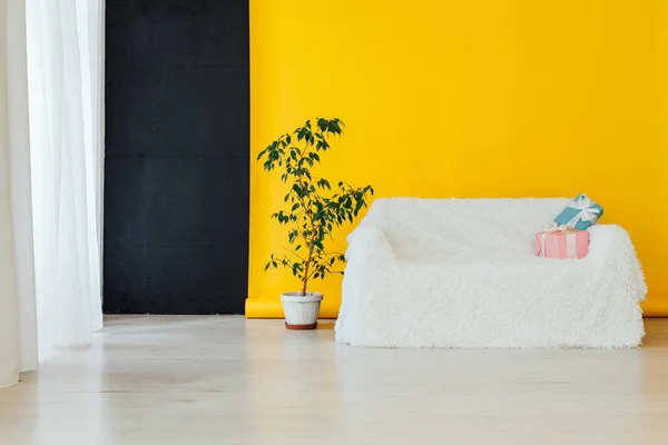 Sofá blanco con regalos en el interior de la habitación con un fondo amarillo — Foto de Stock