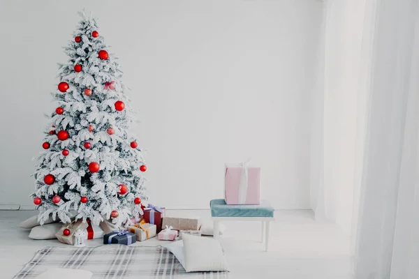 Fehér szobában a karácsonyfa, a piros játékok új év téli ajándék dekoráció — Stock Fotó