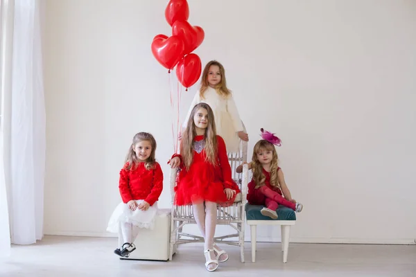 Τέσσερα κορίτσια με κόκκινα και άσπρα ρούχα με μπαλόνια — Φωτογραφία Αρχείου