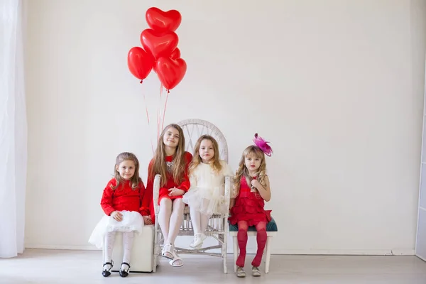 Τέσσερα κορίτσια με κόκκινα και άσπρα ρούχα με μπαλόνια — Φωτογραφία Αρχείου