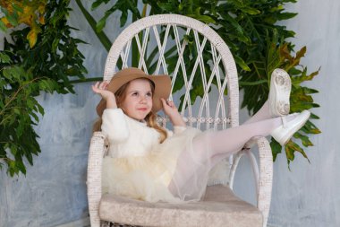 Şapkalı, beyaz elbiseli, şık bir kız.