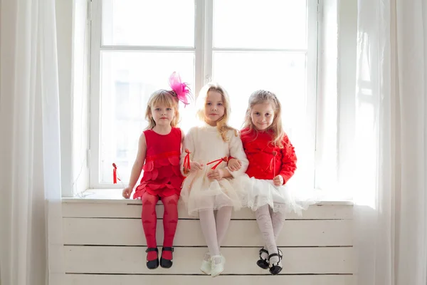 Trzy małe dziewczynki z czerwonymi balonami na imprezie — Zdjęcie stockowe