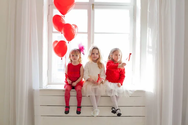 Tre bambine con palloncini rossi alla festa — Foto Stock