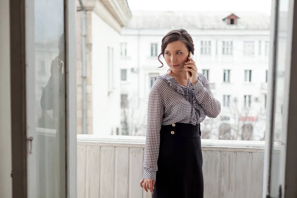 Asian woman talks on her smartphone in the office