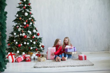 İki kız kardeş yılbaşında Noel hediyelerini açar.