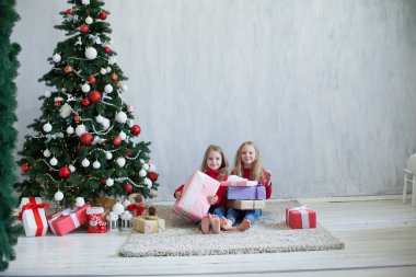 İki kız kardeş yılbaşında Noel hediyelerini açar.