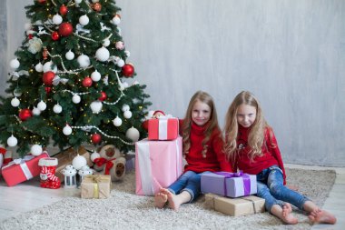 İki kız kardeş yılbaşında Noel hediyelerini açar.