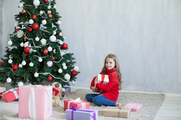 Klein meisje versiert kerstboom geschenken Nieuwjaar — Stockfoto