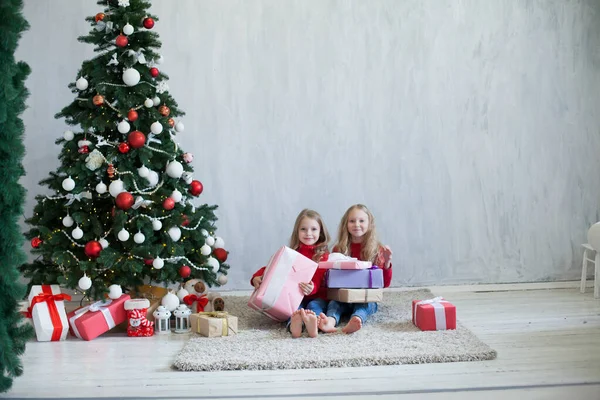 Dwie siostry otwierają prezenty na choinkę w Nowy Rok — Zdjęcie stockowe