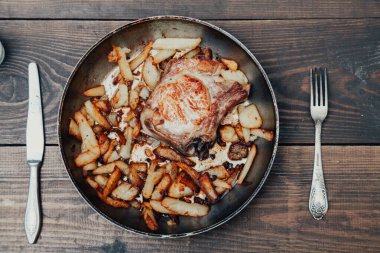 bir tablo üzerinde et ve patates tava ile akşam yemeği kızarmış