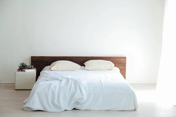 Dormitorio blanco interiores luminosos con cama y flores — Foto de Stock