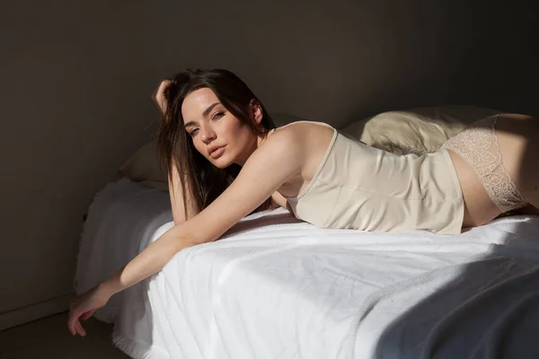 Hermosa mujer en ropa interior ligera en el dormitorio en la cama —  Fotos de Stock