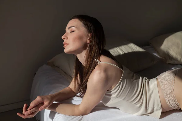 Gyönyörű nő világos fehérneműben a hálószobában az ágyban — Stock Fotó