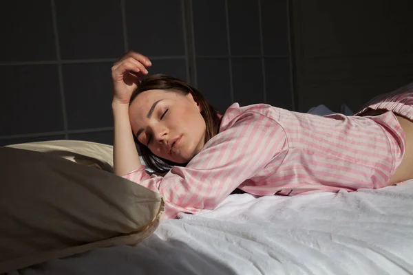 Woman in pink pajamas lies in the morning on a bed sleep — Stock Photo, Image